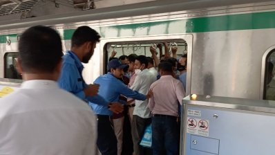 মেট্রোরেলের স্টাফরা ধাক্কা দিয়ে দরজা বন্ধের চেষ্টা করছেন