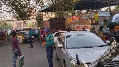 ইন্দ্রিরা রোডে ট্রাফিক পুলিশ সদস্যরা যানবাহন নিয়ন্ত্রণে কাজ করছেন (ছবি: আরমান ভূঁইয়া)