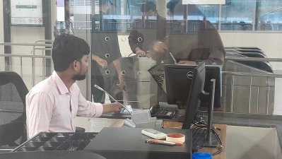 নিজের আসনে বসে কাজ করছে এক স্টাফ