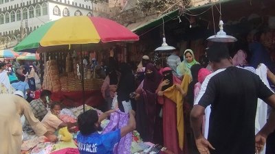 ক্রেতাদের পণ্য দেখাতে ব্যস্ত বিক্রেতা