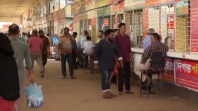 টার্মিনালে বাসের জন্য অপেক্ষা করছেন তারা