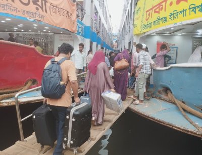 দুহাত ভর্তি জিনিসপত্র নিয়ে লঞ্চে উঠছেন যাত্রীরা