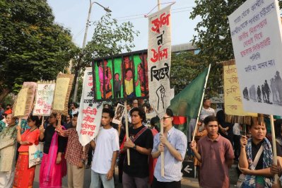 প্লাকার্ড হাতে দাঁড়িয়ে কর্মসূচিতে অংশগ্রহণকারীরা