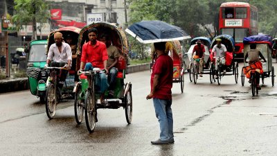 বৃষ্টির মধ্যে বাসের জন্য অপেক্ষা করছেন একজন। ছবি: নাসিরুল ইসলাম