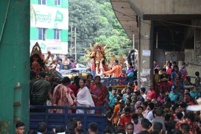 বৈরী আবহাওয়ার মধ্যেও বিসর্জন দেখতে বুড়িগঙ্গার পাড়ে মানুষের ঢল নামে (ছবি: বাংলা ট্রিবিউন)