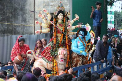 প্রথমে ভ্যানে-ট্রাকে করে প্রতিমা এনে রাখা হয় বুড়িগঙ্গার পাড়ে। কয়েকটি মন্দিরের প্রতিমা একত্রিত হলেই নৌকায় করে নিয়ে বিসর্জন দেওয়া হয় নদীতে (ছবি: বাংলা ট্রিবিউন)