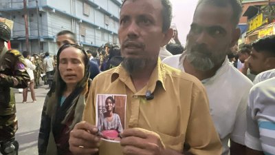 স্বজনের ছবি হাতে ঘটনাস্থলের একজন/আসাদ আবেদীন জয়