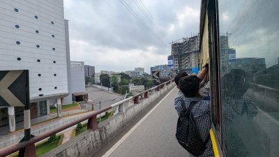 ঝুকি নিয়ে বাসের গেটে ঝুলে আছেন যাত্রীরা (ছবি: প্রতিবেদক)
