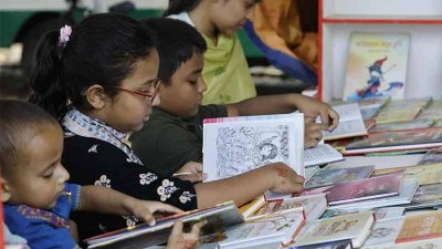 বই দেখছে শিশুরা (ছবি: নাসিরুল ইসলাম)
