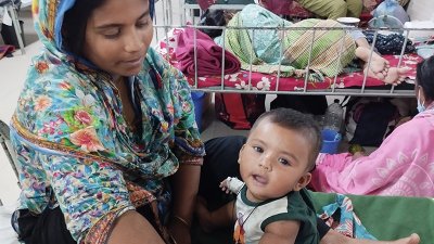 হামে আক্রান্ত শিশুকে নিয়ে বসে আছেন এক মা। ছবি: বাংলা ট্রিবিউন