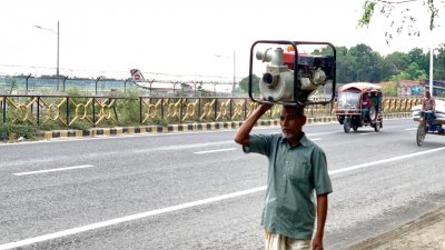 মাথায় করে শ্যালোমেশিন (সেচযন্ত্র) নিয়ে পাম্পে এসেছেন রাজশাহীর কৃষক