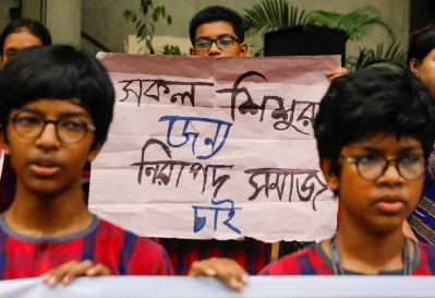 &lsquo;সকল শিশুর জন্য নিরাপদ সমাজ চাই&rsquo; লেখা প্ল্যাকার্ড নিয়ে দাঁড়িয়ে আছে ছায়ানটের এক শিক্ষার্থী। ছবি: আহাদুল করিম খান