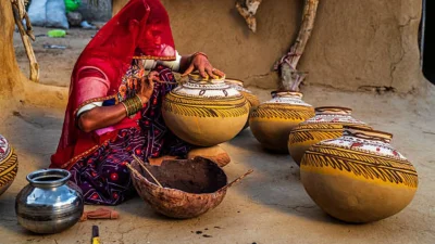 মাটির হাঁড়িতে ঐতিহ্যবাহী নকশা আঁকায় ব্যস্ত স্থানীয় একজন নারী (ছবি: পিক্সেল) 