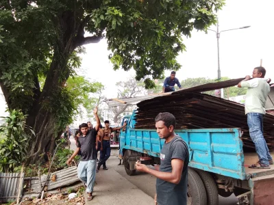 ১১০ নম্বর ভবনের সামনে উঁচু টিন দিয়ে ঘিরে ফেলতে থাকেন অর্ধশতাধিক লোকজন