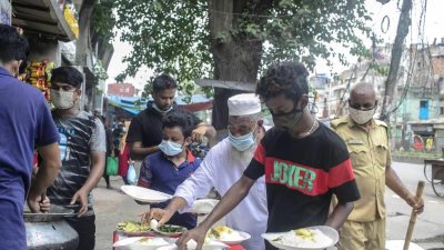 দরিদ্র মানুষের জন্য তৈরি খাবার টেবিলে সাজিয়ে রাখা হচ্ছে। ছবি: সাজ্জাদ হোসাইন