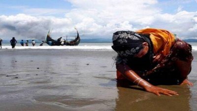 মিয়ানমার থেকে বাংলাদেশের তীরে ক্লান্ত রোহিঙ্গা নারী