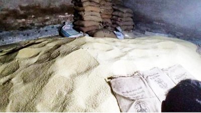 চটের বস্তা থেকে চালগুলো প্লাস্টিকের বস্তায় তোলা হচ্ছিল