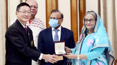 প্রধানমন্ত্রী শেখ হাসিনার হাতে পল্লী উন্নয়ন পদক তুলে দিচ্ছেন সিরডাপের মহাপরিচালক