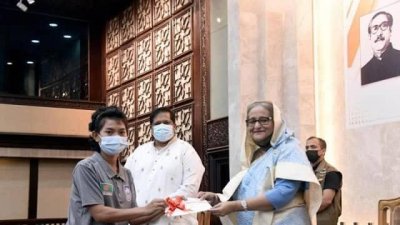 প্রধানমন্ত্রীর কাছ থেকে পুরস্কারের চেক নিচ্ছেন নারী ফুটবলার মারিয়া মান্দা