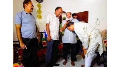 শিক্ষকের পায়ে হাত দিয়ে শ্রদ্ধা নিবেদন করছেন তথ্যমন্ত্রী