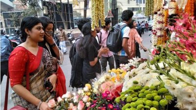রাজধানীর শাহবাগে ফুলের দোকানে ফুল কিনতে আসা কয়েকজন। ছবি: নাসিরুল ইসলাম