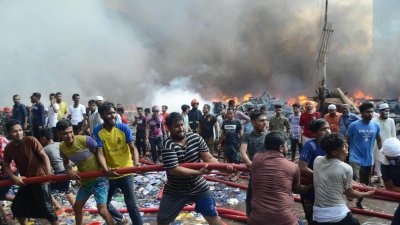 আগুন নিয়ন্ত্রণে ফায়ার সার্ভিসকে সহায়তা করছেন স্থানীয় লোকজন ও ব্যবসায়ীরা (ছবি: নাসিরুল ইসলাম)