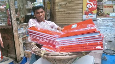 পুরান ঢাকায় ফেরি করে টালিখাতা বিক্রি করেন করিম মিয়া। ছবি: মেহেরাবুল সৌদিপ