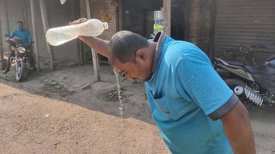 তীব্র গরমে মাথায় পানি ঢালছেন এই ব্যক্তি