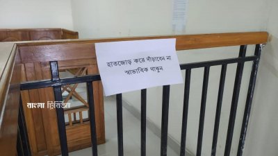 আসামির কাঠগড়ার সামনে একটি কাগজে লেখা, ‘হাত জোড় করে দাঁড়াবেন না, স্বাভাবিক থাকুন’