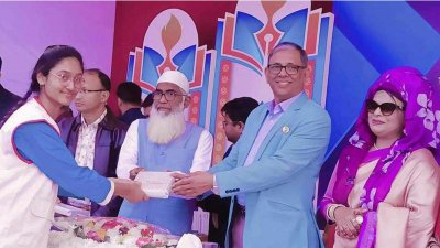 এক শিক্ষার্থীর হাতে পুরস্কার তুলে দিচ্ছেন আ ফ ম বাহাউদ্দিন নাছিম