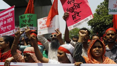 ‘বাঁচার মতো মজুরি চাই’ প্ল্যাকার্ড হাতে শ্রমিকরা। ছবি: সাজ্জাদ হোসেন