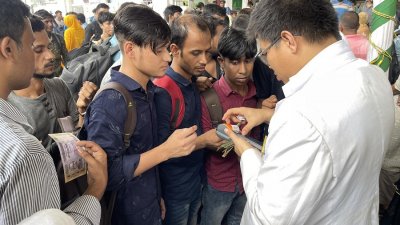 স্টেশনে জরিমানার অগ্রিম টিকিট দিচ্ছেন একজন টিটিই