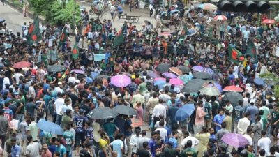 বৃষ্টির মধ্যে অবস্থান নিয়ে তাদের দাবির পক্ষে স্লোগান দেন শিক্ষার্থীরা। ছবি: সাজ্জাদ হোসেন