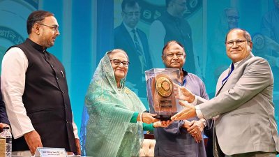 প্রধানমন্ত্রী শেখ হাসিনার কাছ থেকে ‘জাতীয় রফতানি ট্রফি’র স্বর্ণ পদক গ্রহণ করছেন ওয়ালটন হাই-টেক ইন্ডাস্ট্রিজ পিএলসি’র সাবেক চেয়ারম্যান ও বর্তমান পরিচালক এস এম নূরুল আলম রেজভী।