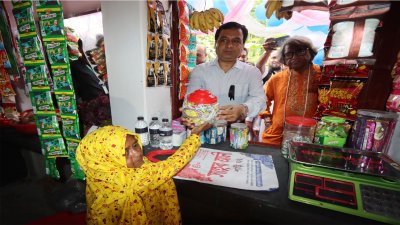 প্রথম বিক্রেতা জেলা প্রশাসকের হাতে পণ্য তুলে দিচ্ছেন মাসুরা বেগম