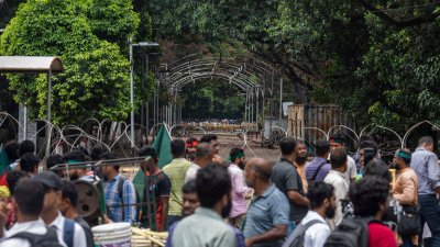 ধানমন্ডি ৩২ নম্বর সড়কের আশপাশের এলাকায় অবস্থান করছেন অনেক লোকজন। ছবি: সাজ্জাদ হোসেন