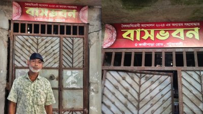 বাড়ির গেটে লাগানো সাইনবোর্ডের সঙ্গে ইলিয়াস হোসেন