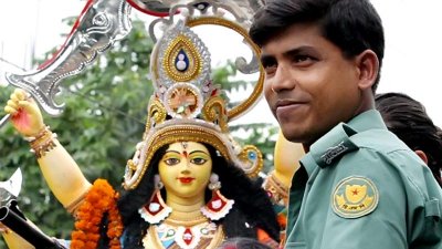 দেবী দুর্গার সঙ্গে ডিএমপির এক সদস্য (ছবি: ডিএমপি নিউজ)