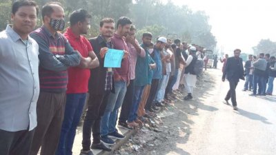 সড়কে অবস্থান নিয়ে বিক্ষোভ করছেন শ্রমিকরা