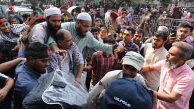 ৩২ নম্বরে আওয়ামী লীগ সন্দেহে এক নারীসহ দুই জনকে গণপিটুনি দিয়েছে ছাত্র-জনতা। ছবি: সাজ্জাদ হোসেন