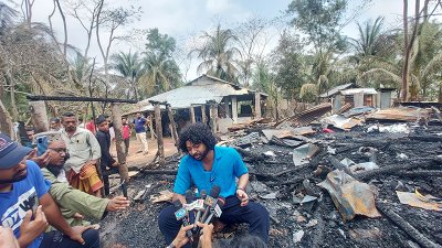 আগুনে পুড়ে যাওয়া ধ্বংসস্তূপের ওপর বসা কাফি