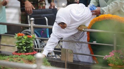 বনানী সামরিক কবরস্থানে এক শহীদ সেনা কর্মকর্তার কবরে তার এক স্বজন (ছবি: নাসিরুল ইসলাম)
