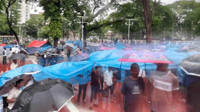 বৃষ্টিতে ভিজে আন্দোলন চালিয়ে যাচ্ছেন পবিস কর্মীরা