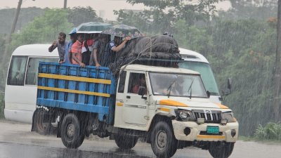 খোলা পিকআপে বৃষ্টিতে ভিজে বাড়ি ফিরছে মানুষ