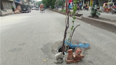 পান্থপথ এফ আর টাওয়ারের সামনের সড়কে ম্যানহোলে ঢাকনা না থাকায় লাঠি ও ইট রেখে  যানবাহন চালকদের সতর্ক করার চেষ্টা