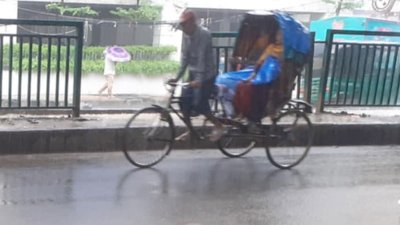 মগবাজারে বৃষ্টির মধ্যে চলছে রিকশা, ছাতা হাতে পথচারী (ছবি: আল আমিন হোসেন পলাশ)