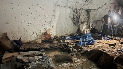 গাজায় আল-শিফা হাসপাতালের বাইরে স্থাপিত তাঁবুতে হামলা চালিয়েছে ইসরায়েলি সেনাবাহিনী। ওই স্থান পরিদর্শন করছে ফিলিস্তিনিরা। ছবি: রয়টার্স।