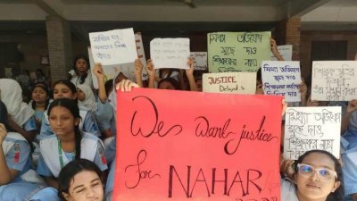 শিক্ষককে বরখাস্তের ঘটনায় বিভিন্ন প্ল্যাকার্ড হাতে প্রতিবাদ জানান শিক্ষার্থীরা