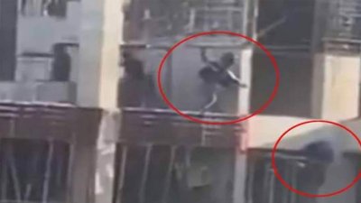 ঢাকার রামপুরায় ভবনের কার্নিশে ঝুলে থাকা তরুণকে গুলি করছেন একজন পুলিশ সদস্য/ভিডিও থেকে নেওয়া স্ক্রিনশট