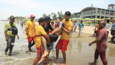 স্রোতে ভেসে যাওয়া এক পর্যটককে উদ্ধার করে নিয়ে যাচ্ছেন লাইফগার্ডের সদস্যরা